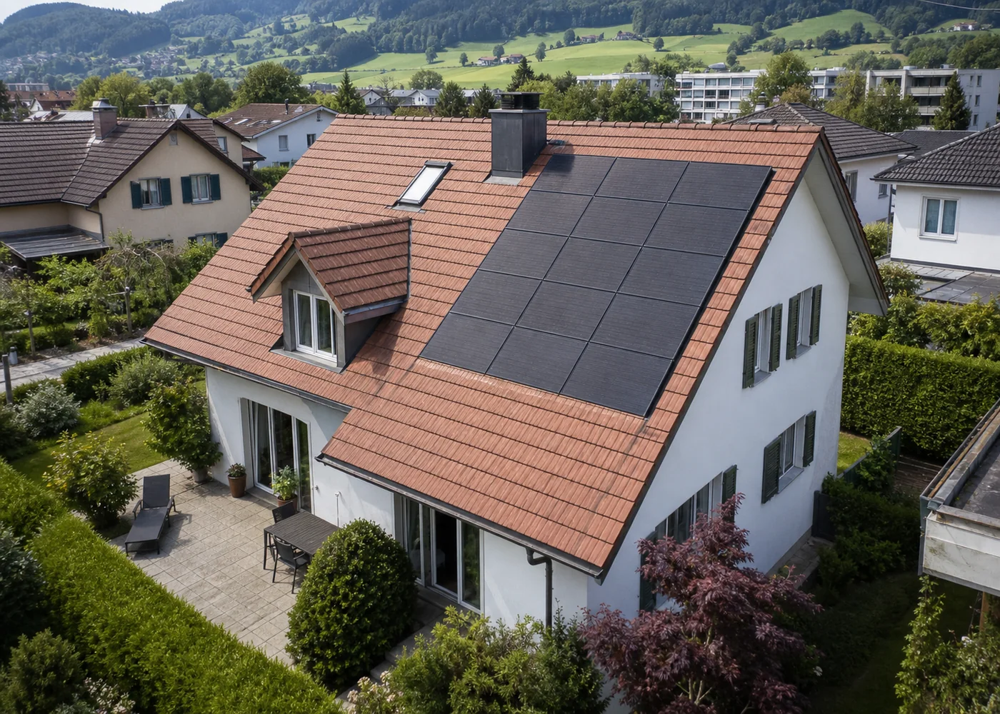 Luftaufnahme eines Schweizer Hauses mit mehreren Dachflächen und Photovoltaik